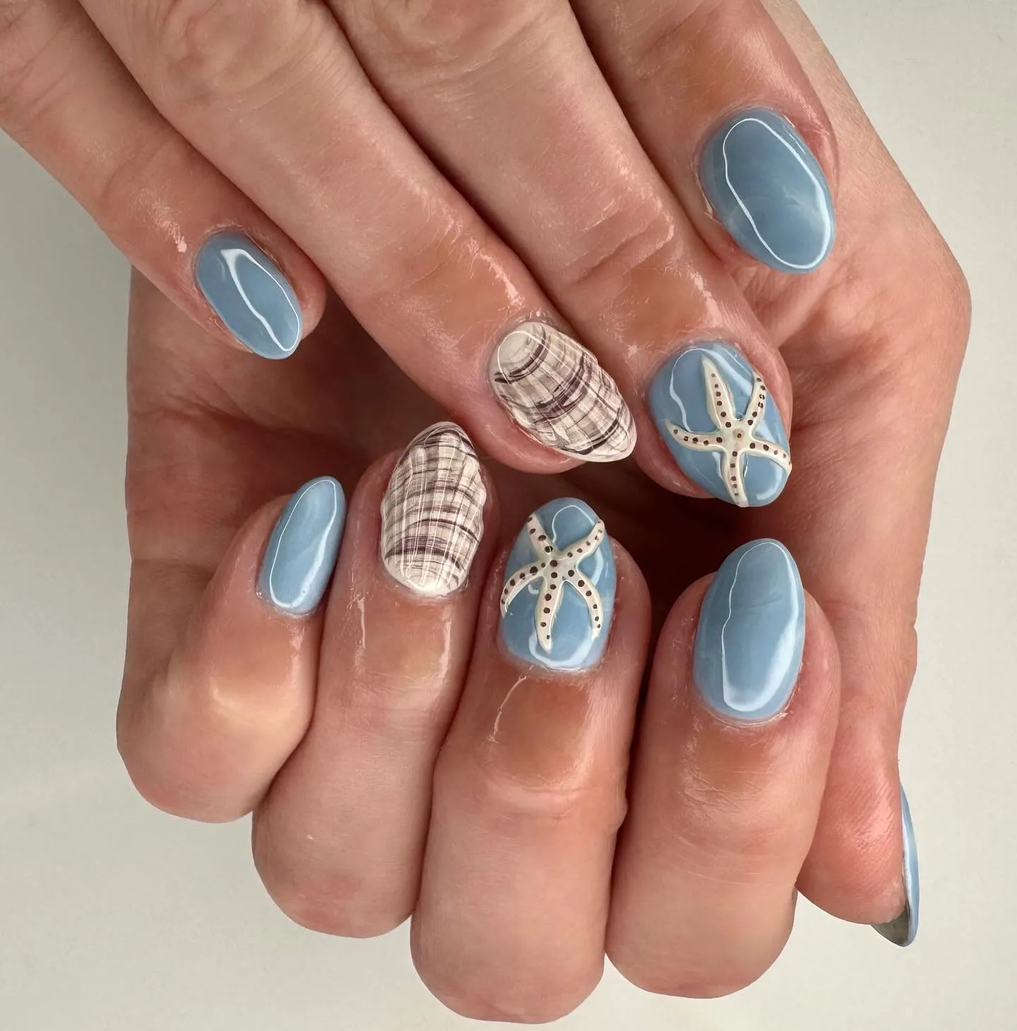 Coastal manicure with raised seashell and starfish details
